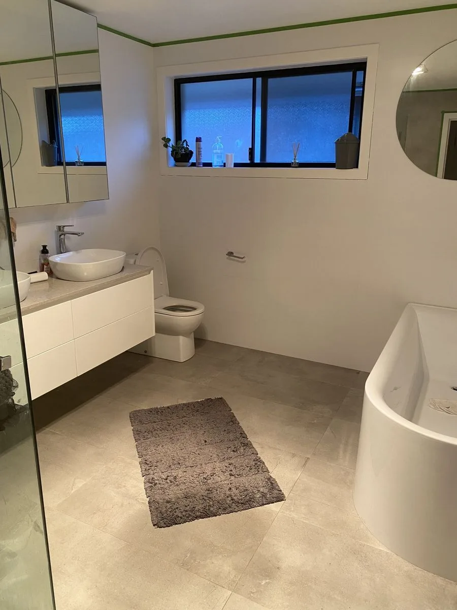Completed bathroom renovation with freestanding bath, vanity and toilet installed by AH Plumbing & Maintenance