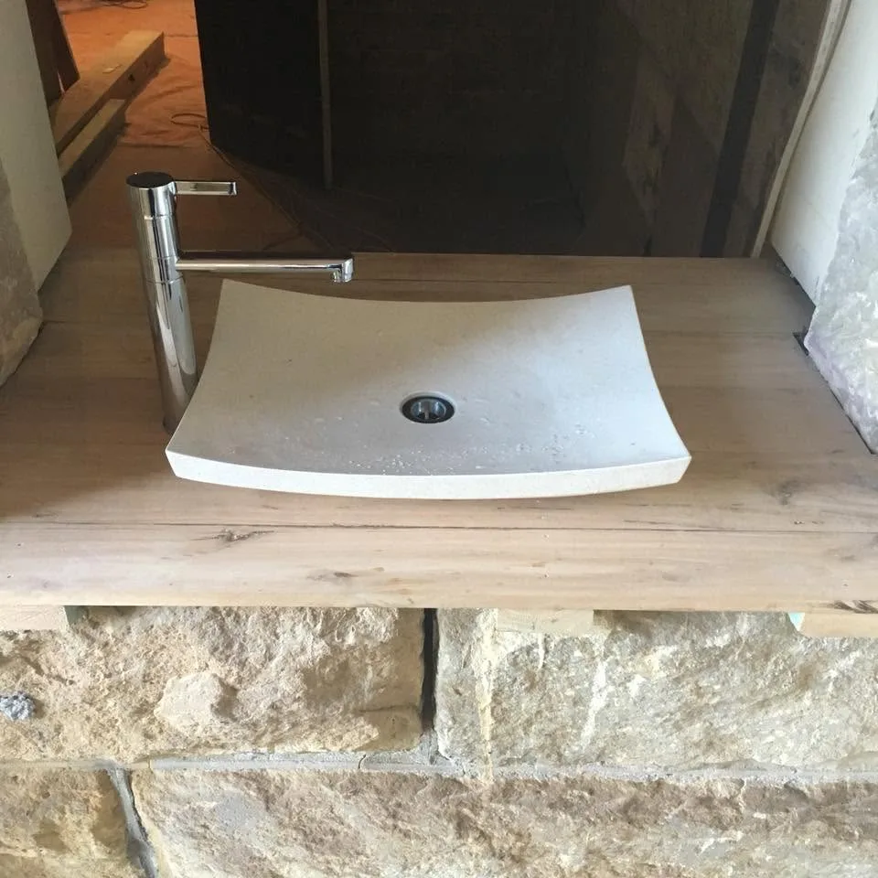 Stone basin on a timber bench installed by AH Plumbing & Maintenance