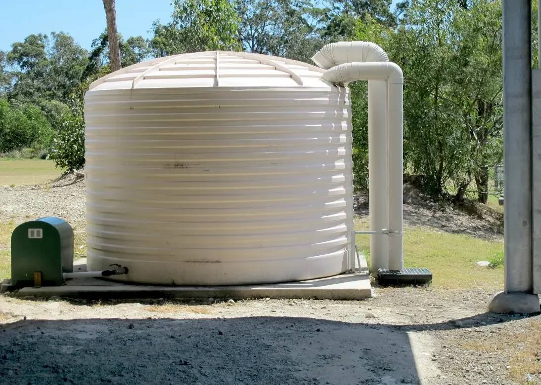 Cream rainwater tank installed on a property