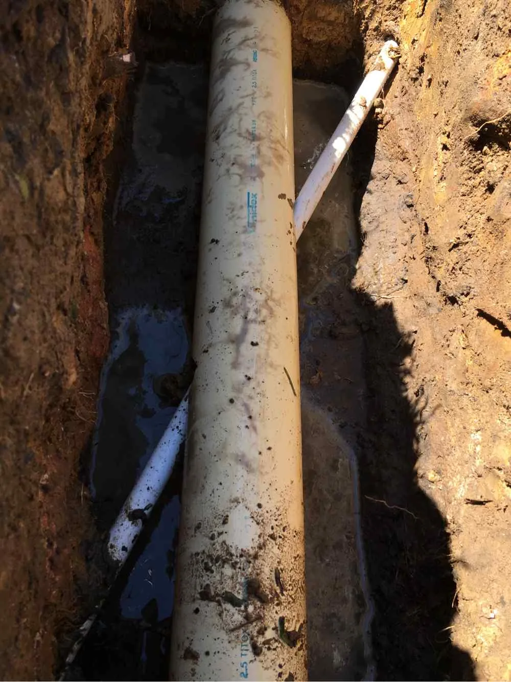 Close-up of a pipe in an excavated trench during a CCTV pipe inspection on the Central Coast