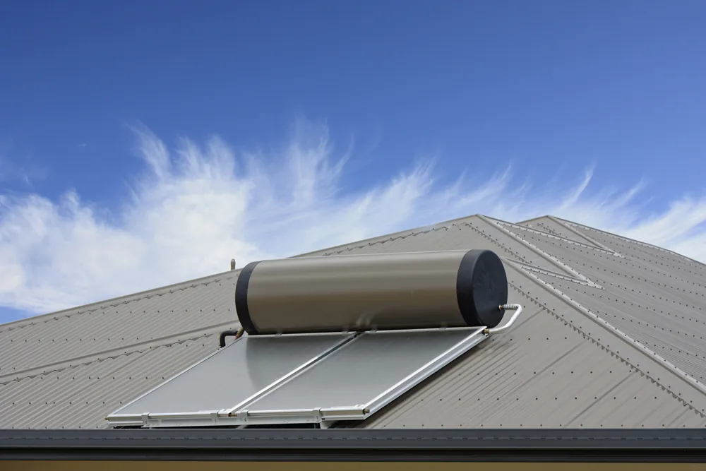 Roof-mounted solar hot water storage tank and collectors on a metal roof
